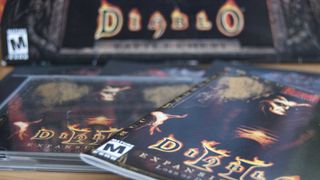 A close-up view of "Diablo" video game cases, including "Diablo II" and its expansion, featuring dark and vibrant artwork.