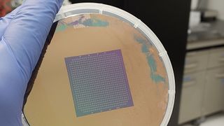 A person holding an object that looks like petri dish with a square electrical mesh in the center