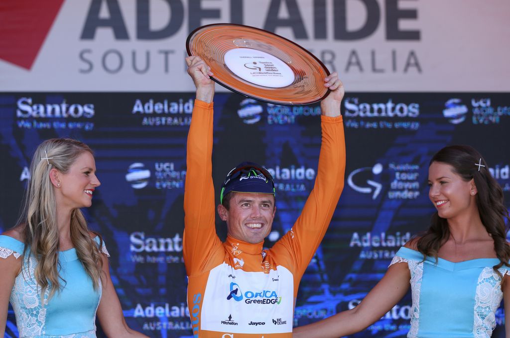 SImon Gerrans holding his winner's trophy aloft after sealing victory in 2016