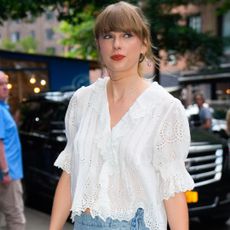 Taylor Swift spotted out in New York wearing Free People denim mini skirt and white blouse from Dôen. 