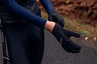 Male cyclist pulling on a pair of cycling gloves