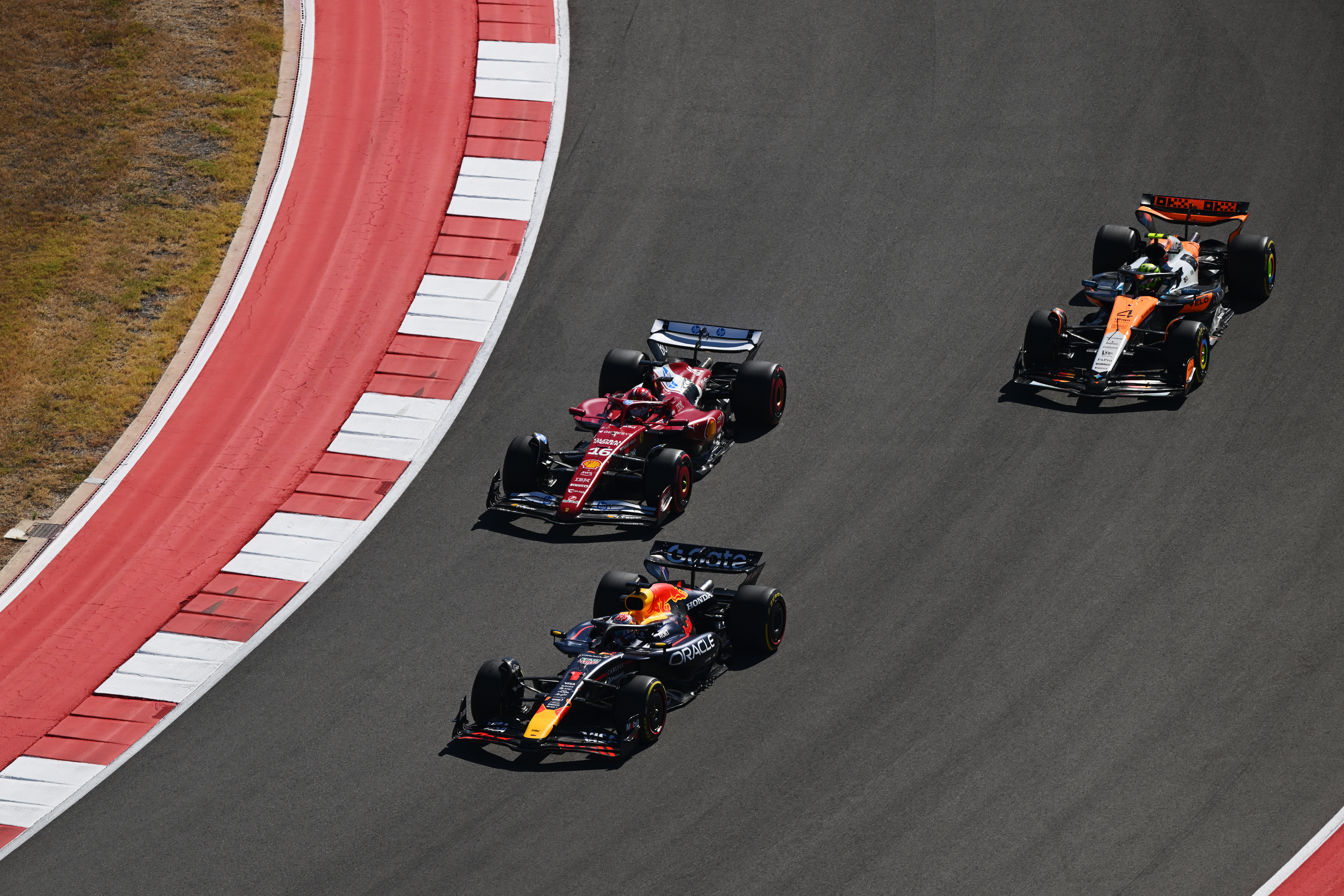 AUSTIN, TEXAS - OCTOBER 19: Max Verstappen of the Netherlands driving the (1) Oracle Red Bull Racing RB21 leads Charles Leclerc of Monaco driving the (16) Scuderia Ferrari SF-25 and Lando Norris of Great Britain driving the (4) McLaren MCL39 Mercedes at the start during the F1 Grand Prix of United States at Circuit of The Americas on October 19, 2025 in Austin, Texas.