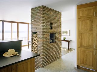 A detail of the living space in Villa Arkö shows the brick fireplace that goes all the way to the ceiling, taken from the kitchen.