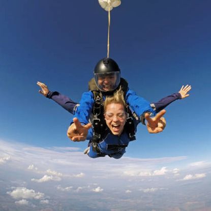 Two people skydiving smiling at the camera