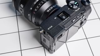 The Sony A7CR on a white table with a blue wall in the background