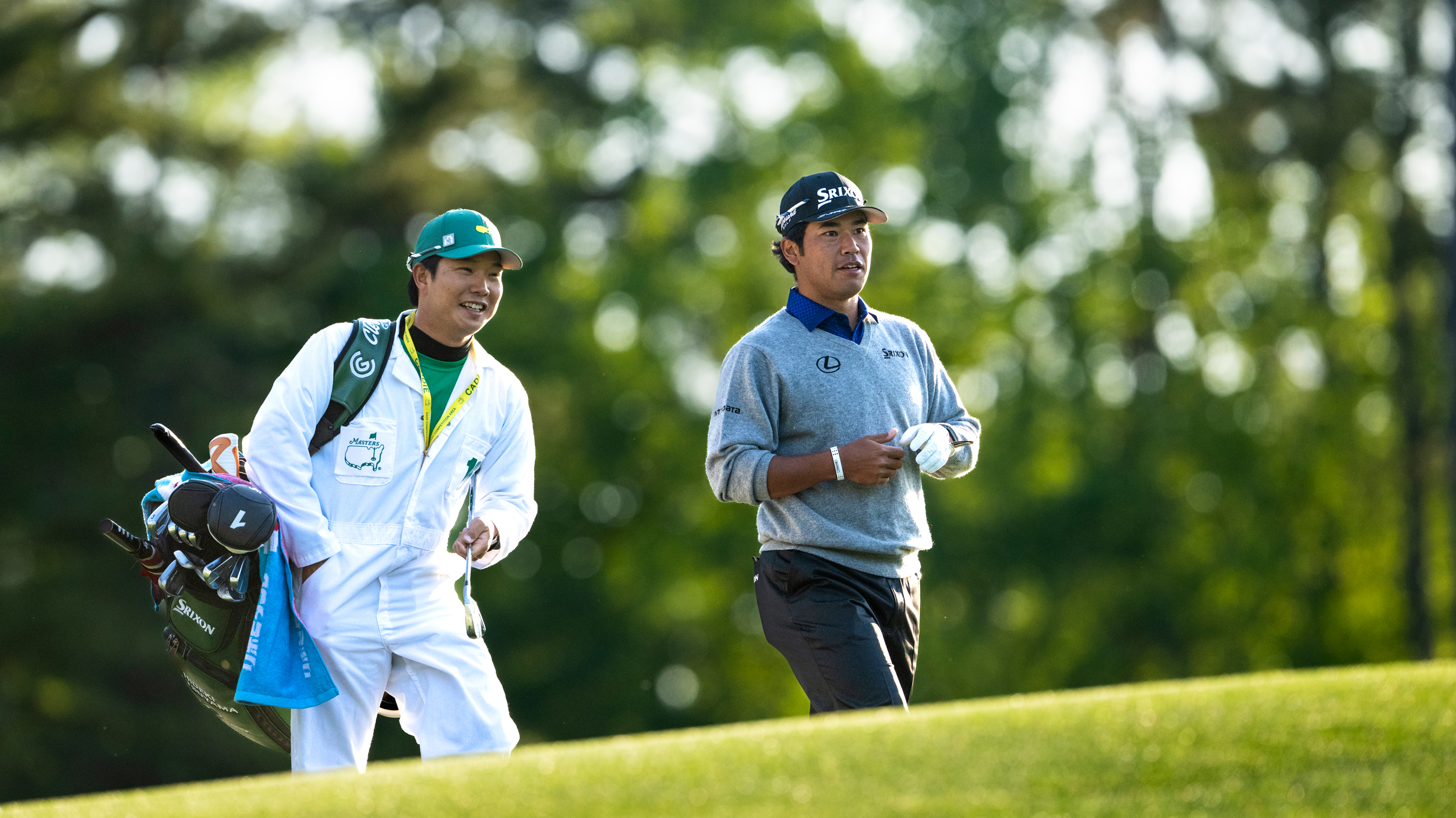 Hideki Matsuyama and his caddie, Shota Hayafuji walk along the 12th at Augusta National