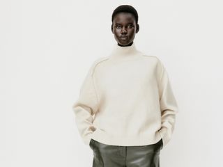 model wears white sweater and green wide leg pants