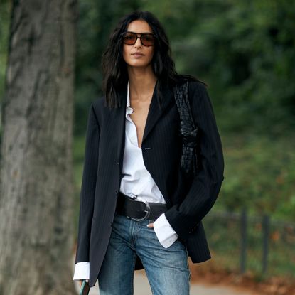 woman wearing rich-looking outfit (blazer, button-down shirt, jeans) 