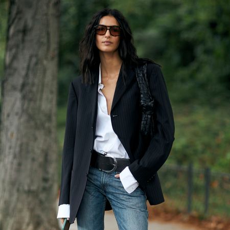 woman wearing rich-looking outfit (blazer, button-down shirt, jeans) 