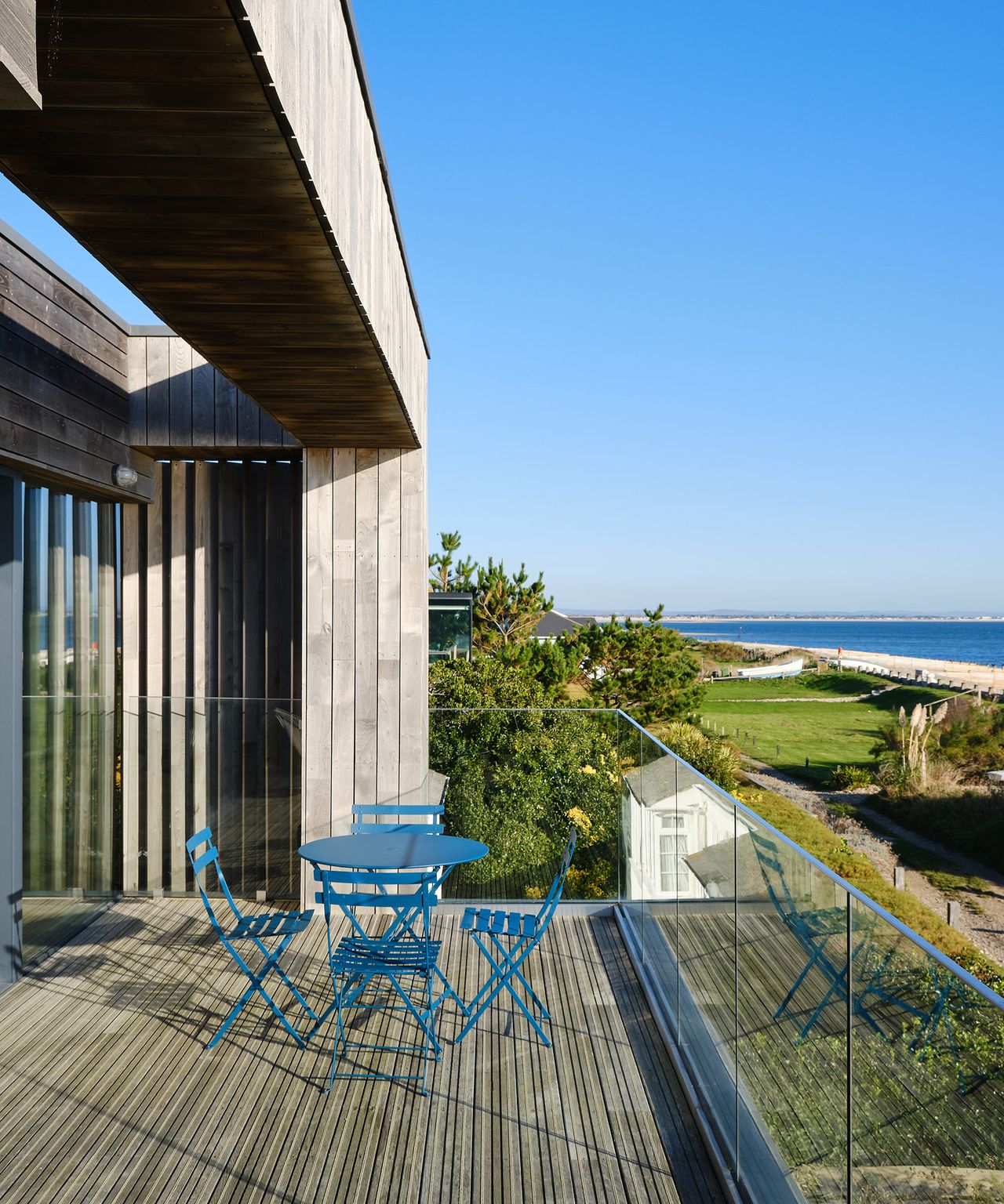 a sun drenched terrace with larch cladding and bistro dining table