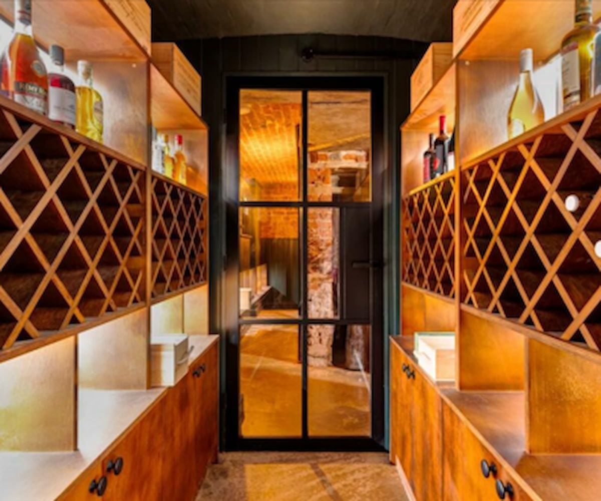 A wine cellar with wine bottles hanging in the walls
