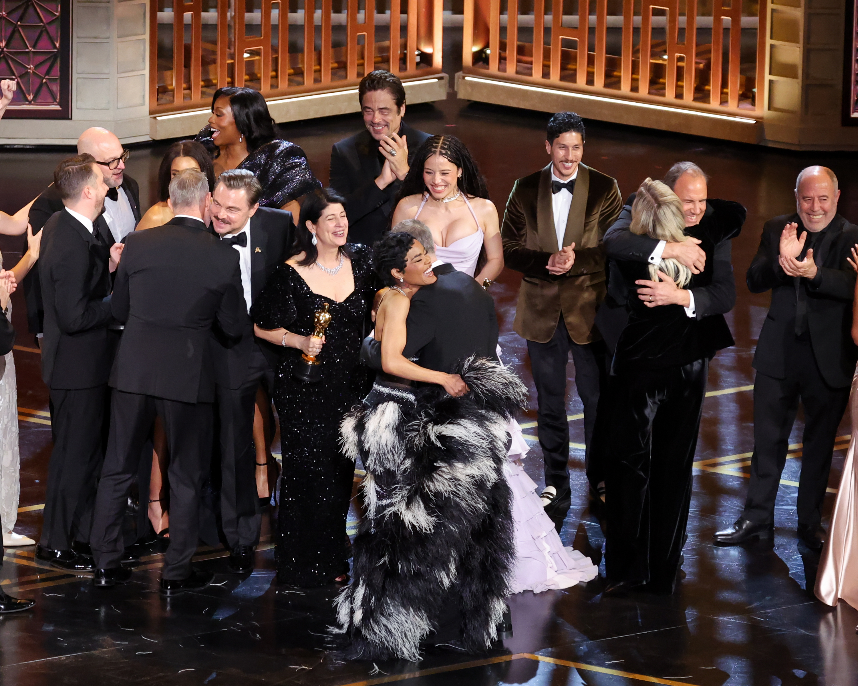 Michael Bauman, Shayna McHayle aka Junglepussy, Leonardo DiCaprio, Cassandra Kulukundis, Benicio del Toro, Chase Infiniti, Tony Villaflor, Christopher Scarabosio and Jos&eacute; Antonio Garcia cheer and look excited and teyana taylor hugs filmmmaker paul thomas anderson as one battle after another is announced the best picture winner at the 98th Annual Oscars held at Dolby Theatre on March 15, 2026 in Hollywood, California