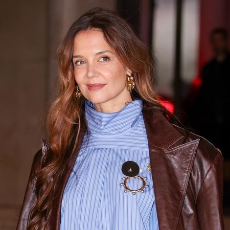 Katie Holmes arrives at the Patou show wearing a brown leather jacket and a backward button down shirt