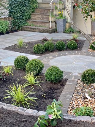small front garden ideas: round paving and clipped evergreens in plot designed by Elly's Wellies Garden Designs