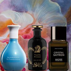 Three bottles of perfume in front of a floral background. 