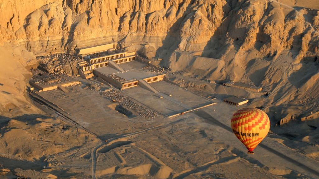 : 2023年2月2日、エジプトのルクソールで、ヨルダン川西岸沿いのハトシェプスト女王葬祭殿の上空を飛ぶ熱気球の航空写真。
