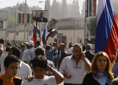 Syrian pro-government protesters rally in front of the Russian Embassy in Damascus