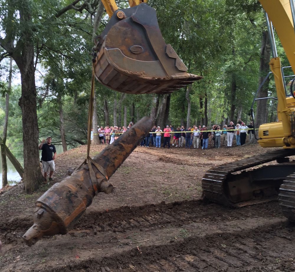 A cannon is lifted by a huge tractor.