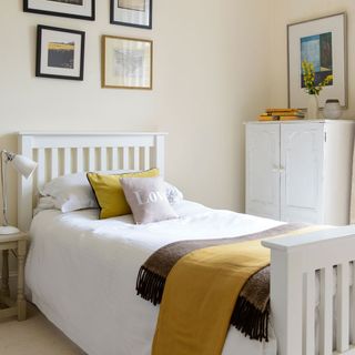 bedroom with white furniture and wall frame