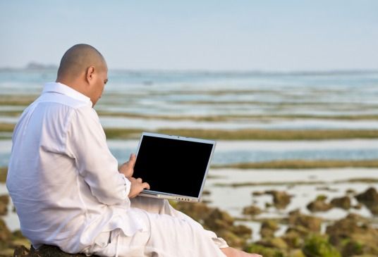 Man surfing the web at the ocean