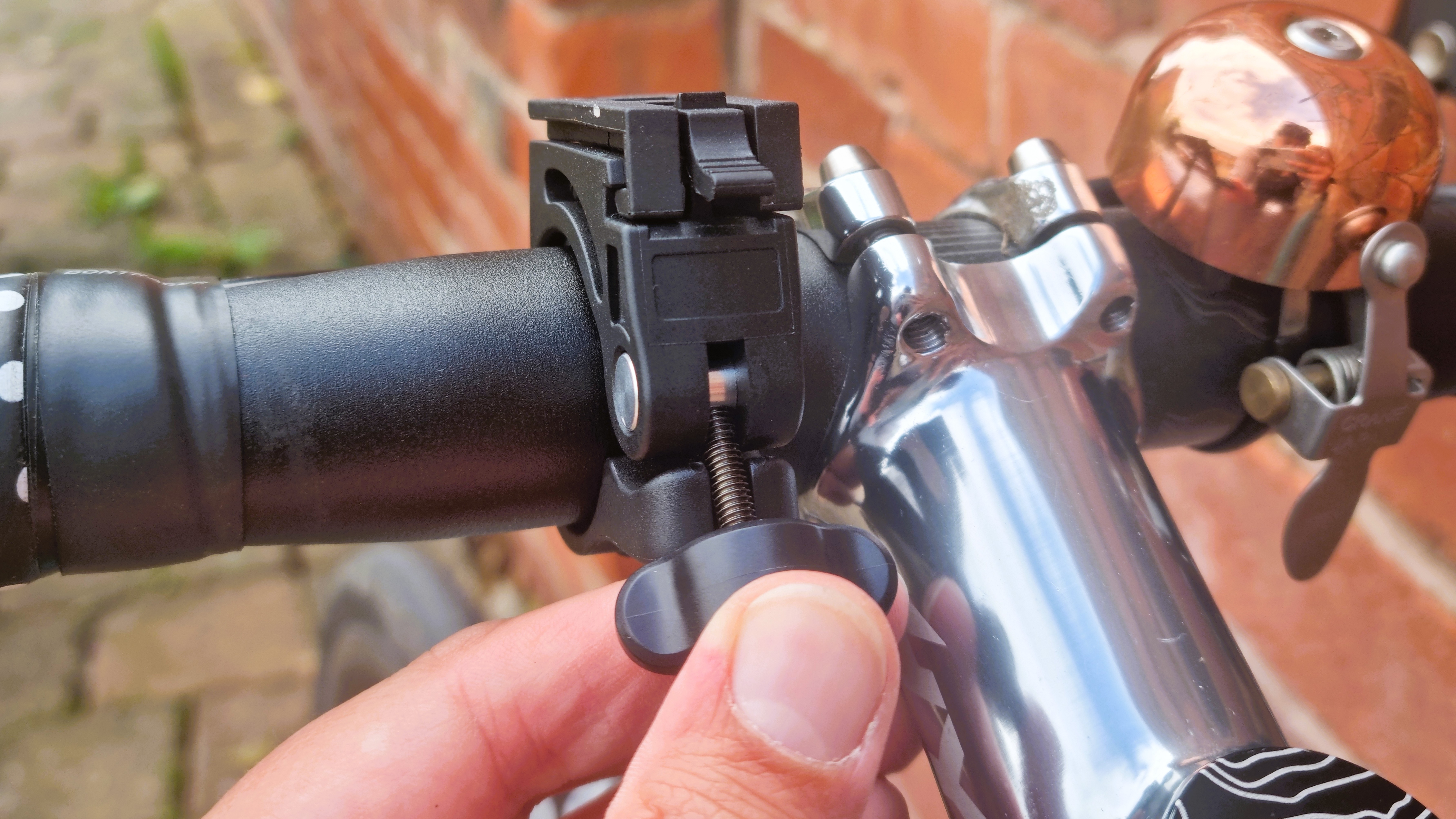 A close up of the PDW City Rover 700 mount with a hand loosening the grip