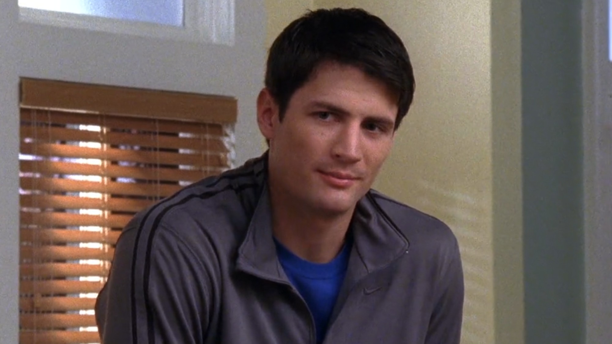 Nathan leaning against the counter on One Tree Hill.