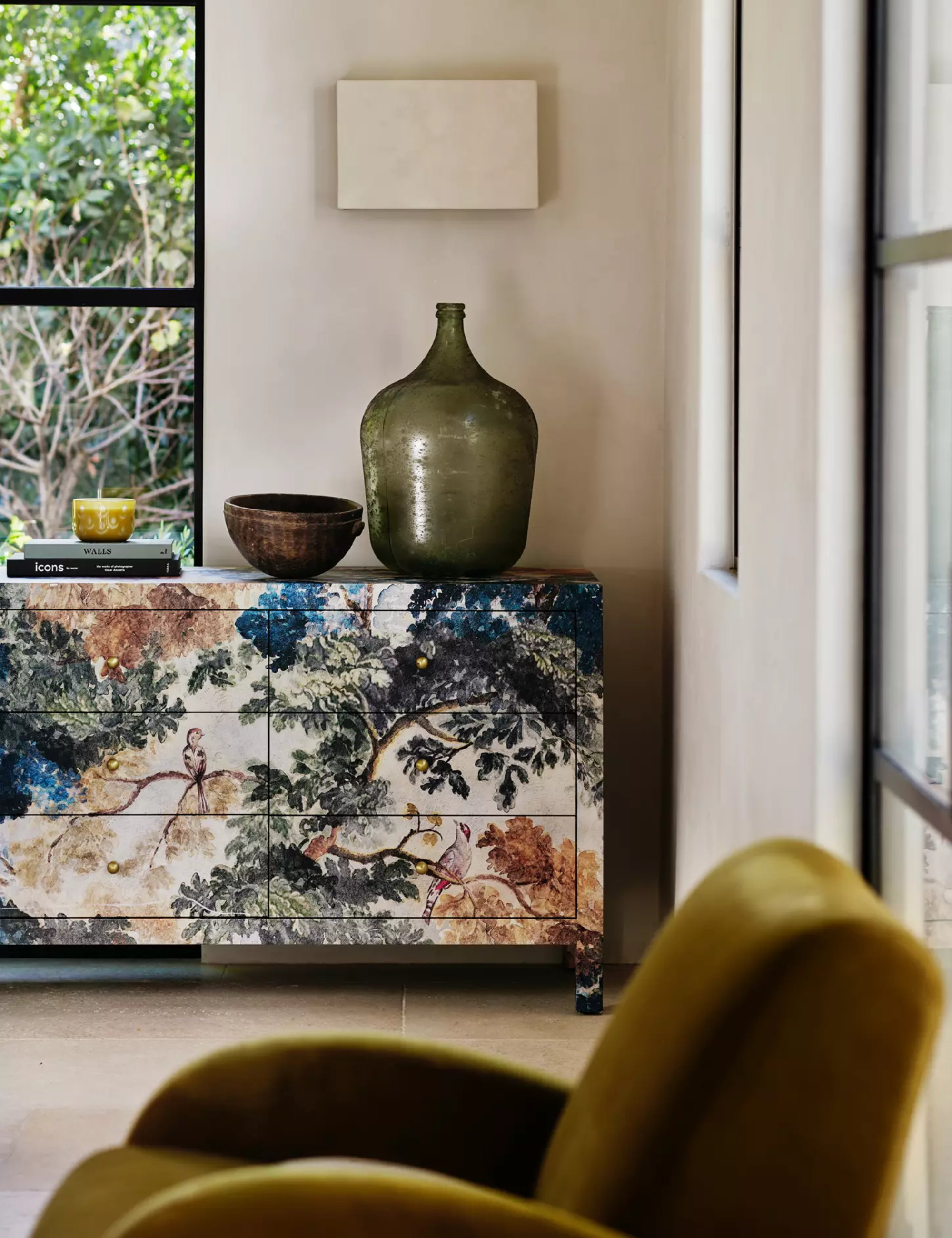 Tapestry-patterned Hale Nine-Drawer Dresser pictured in a soothing living room alongside a sculptural case and velvet accent chair