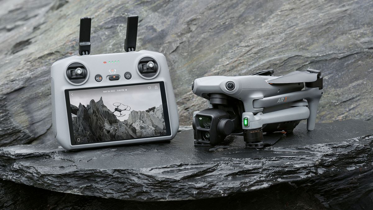 DJI Air 3 drone in folded position on a rock, alongside RC2 controller