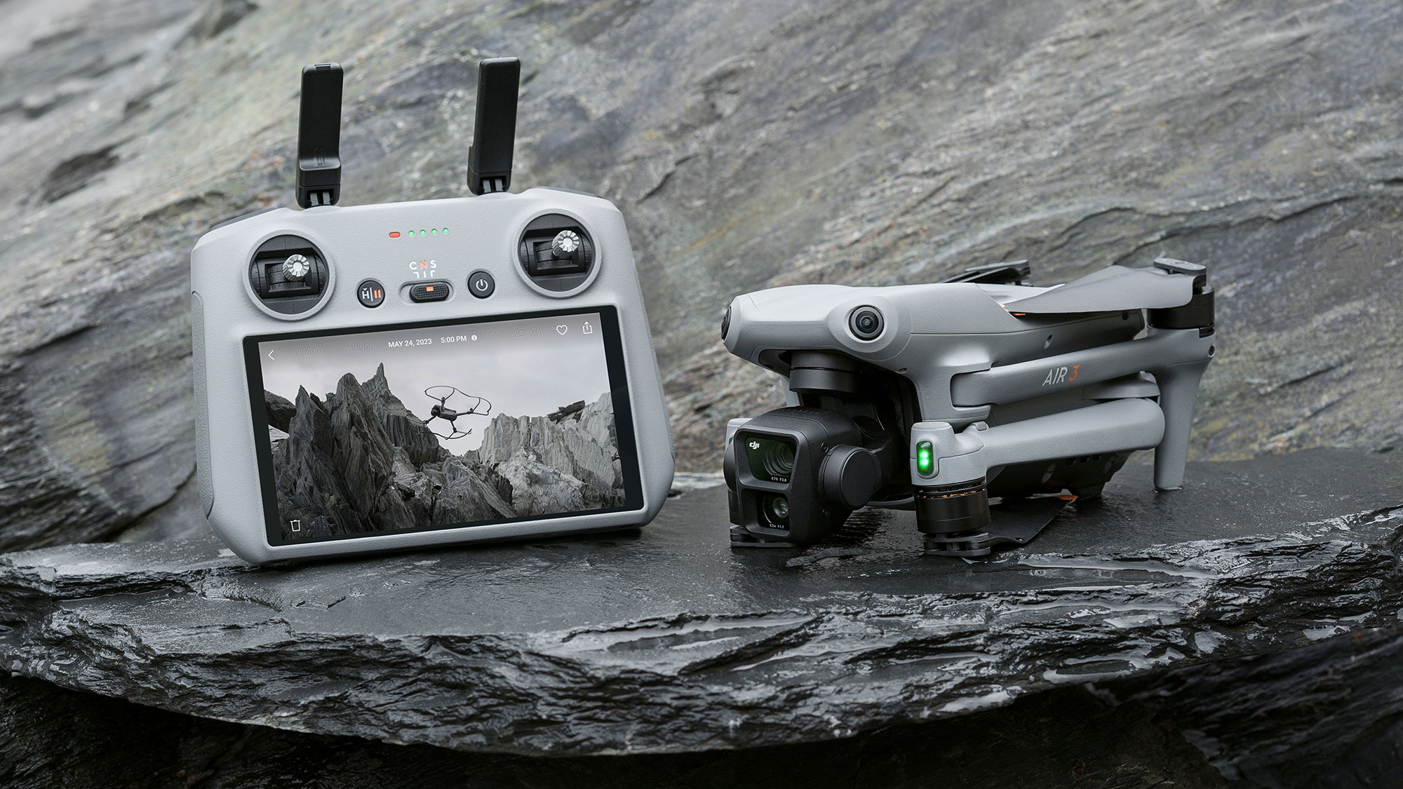 DJI Air 3 drone in folded position on a rock, alongside RC2 controller