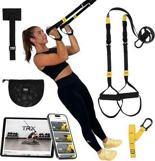 A woman uses the TRX Go strap for training