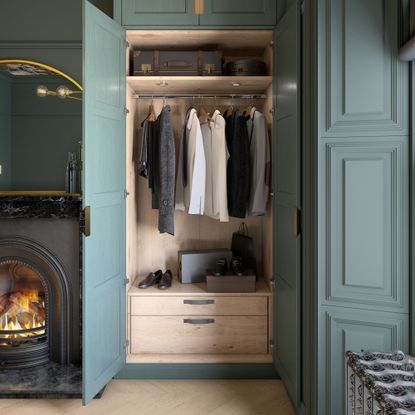 close up of a wall of fitted wardrobes with two doors open revealing shelf hanging rail and two drawers