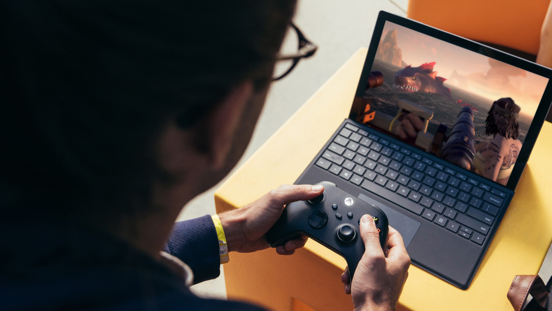 A person playing a game using an Xbox controller on a Surface Pro 