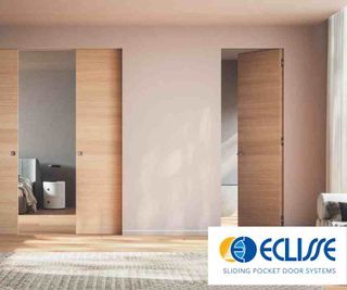A modern landing painted in a light pink colour, with timber floors and a natural woven mat. The landing features two doors from Eclisse; one is a double pocket door.
