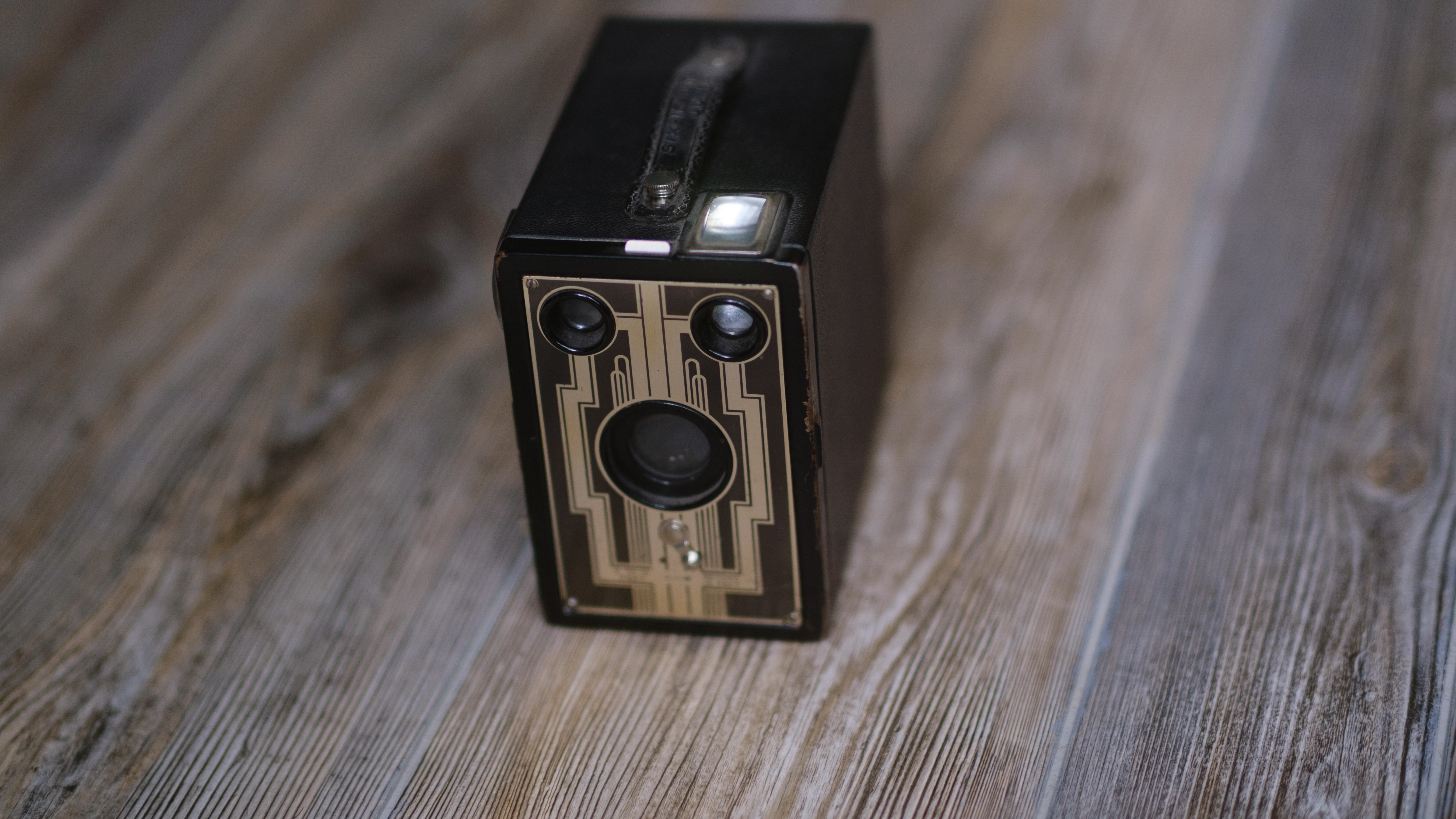 A photo of a vintage box camera taken under different lighting conditions