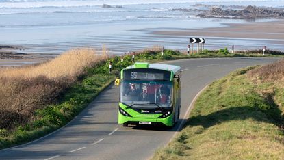 Single deck bus service at Widemouth Bay, close to Bude, north Cornwall with a backdrop of the sea