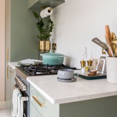 kitchen with green cabinets and white worktops with hob