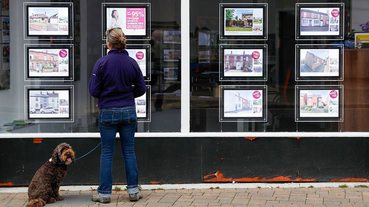 Woman looking in an estate agent&amp;#039;s window