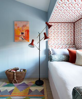 Small bedroom with blue walls and patterned rug