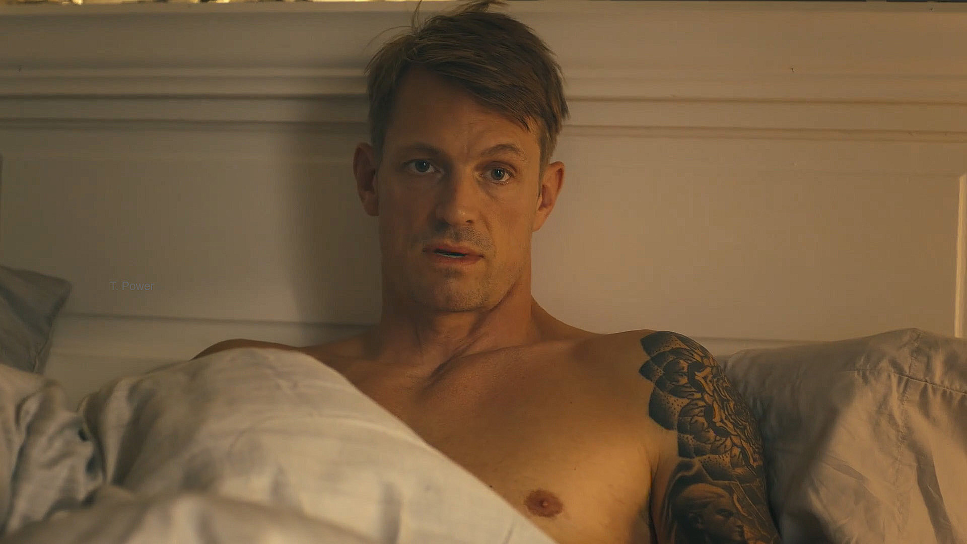 A topless Rick Flag Jr sitting up in a bed in Peacemaker season 2 episode 3