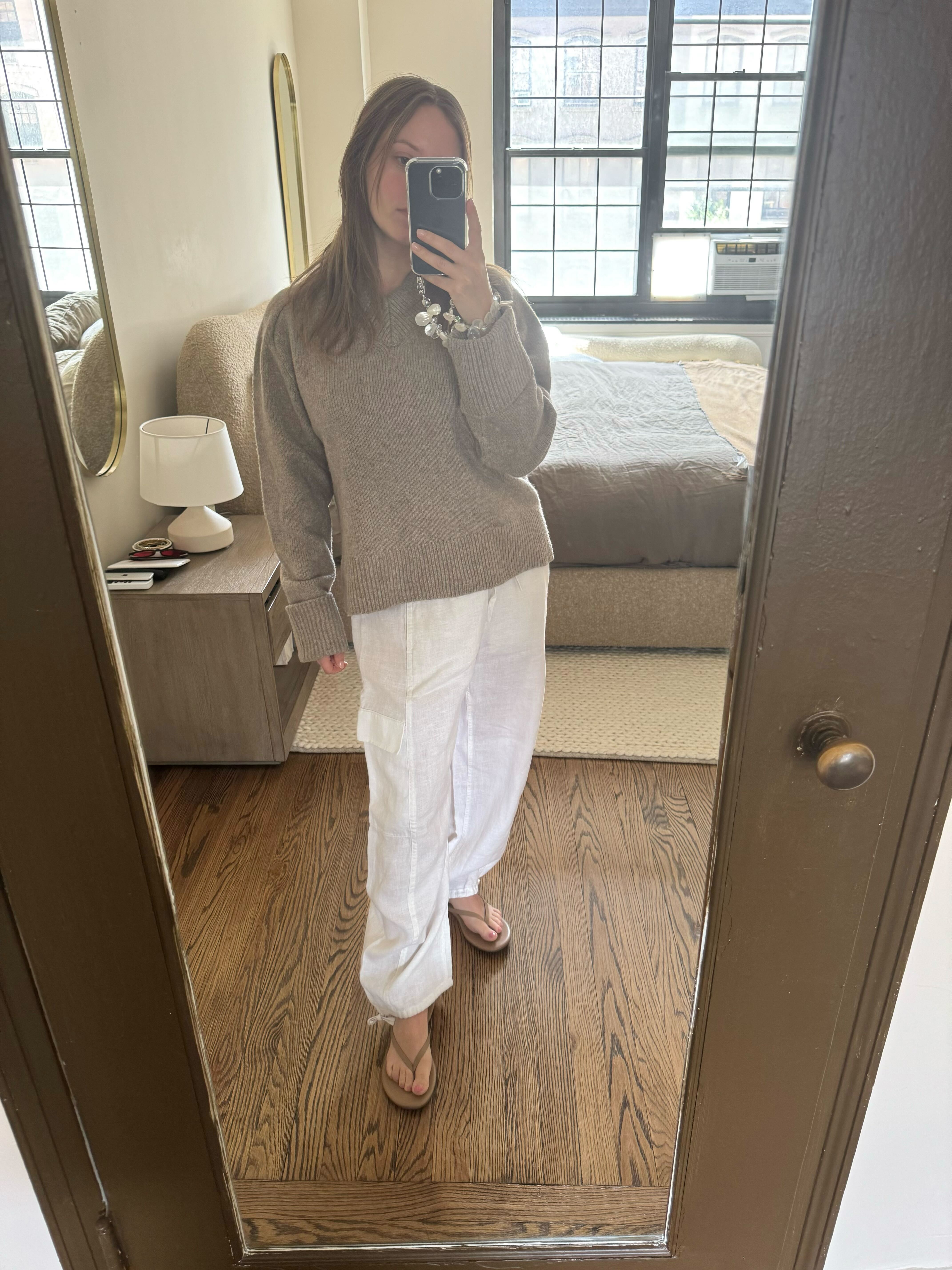 Nikki wears cargo linen pants and a beige sweater.