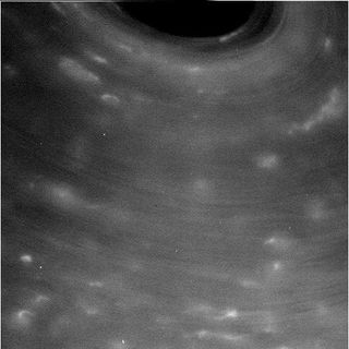 This raw image from NASA's Cassini spacecraft, taken during its closest-ever approach to Saturn's cloud tops, shows the edge of a dark, swirling storm on the planet.