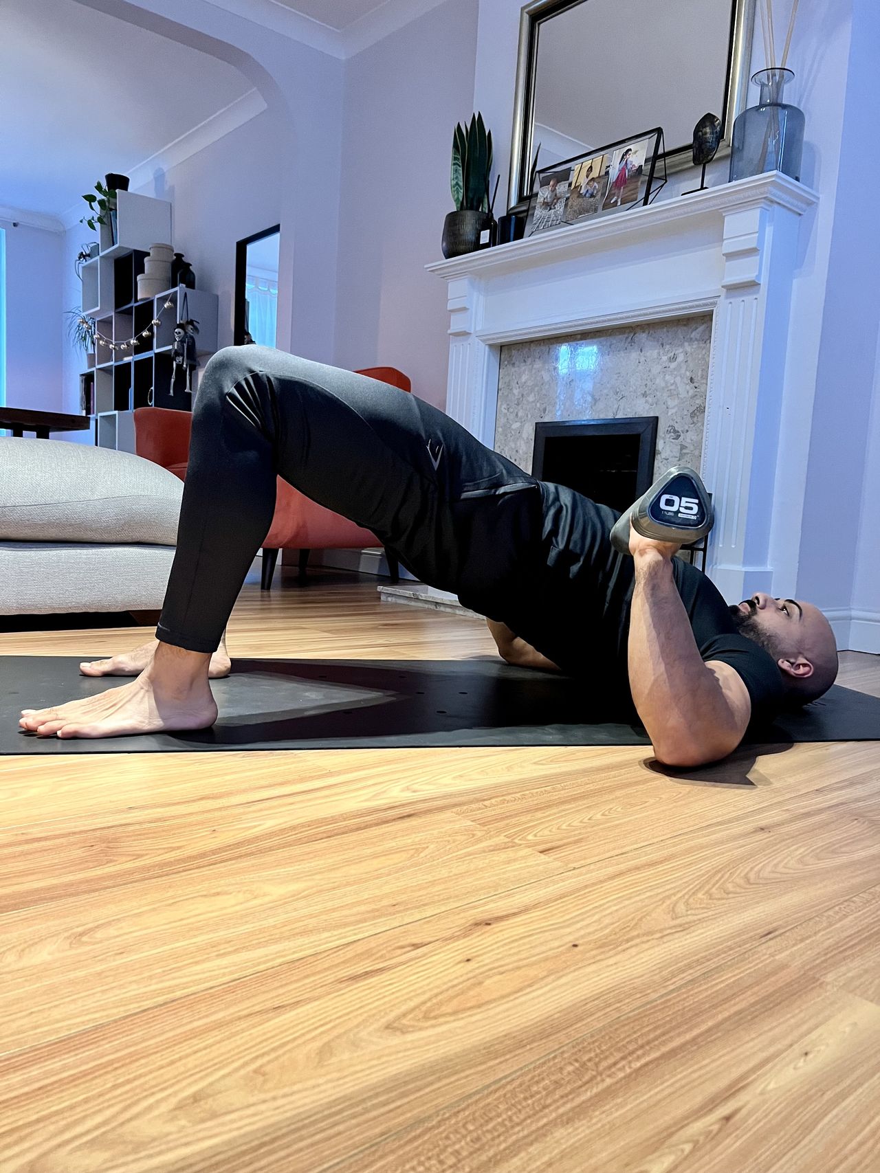 Personal trainer Ali Malik demonstrating the glute bridge chest press