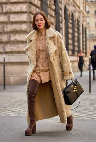 a street-style photo of a woman carrying a Hermés bag in a story about how to buy a hermés bag