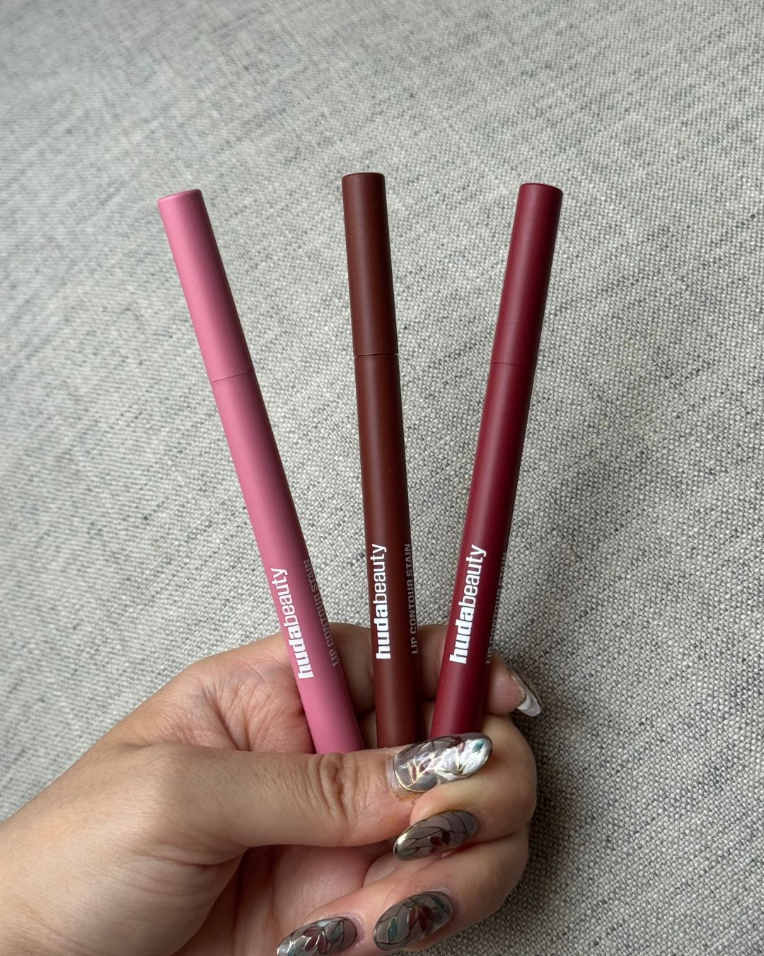 An image showing three shades of the Huda Beauty Lip Contour Stain