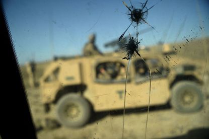 U.S. Army soldiers from NATO are seen through a cracked window of an armed vehicle in a checkpoint in Afghanistan.