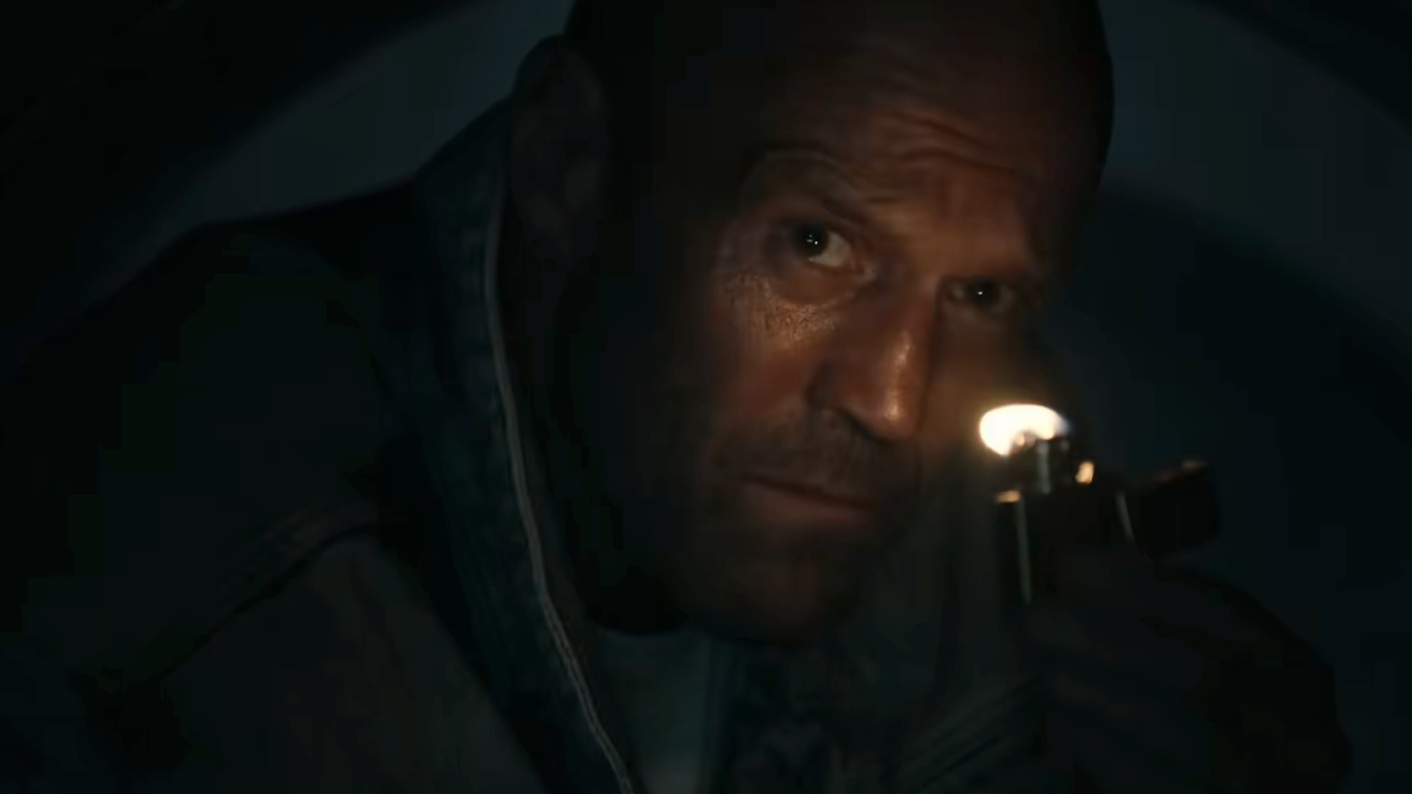 Jason Statham lit only by a zippo lighter in Mutiny