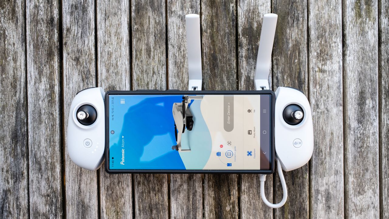 Potensic Atom controller with a phone running the Potensic Pro app