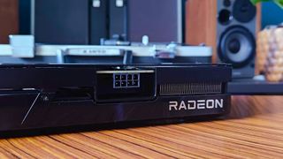 Close up of Radeon logo on AMD GPU sitting on woodgrain table.