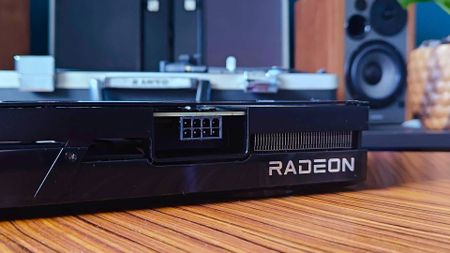 Close up of Radeon logo on AMD GPU sitting on woodgrain table.