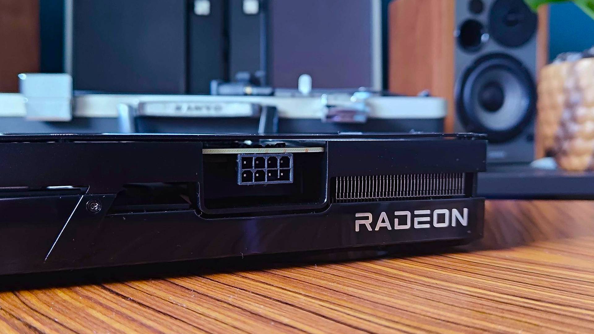 Close up of Radeon logo on AMD GPU sitting on woodgrain table.